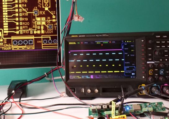 Electronics test bench with an oscilloscope, bench power supply, multimeter and development boards under test